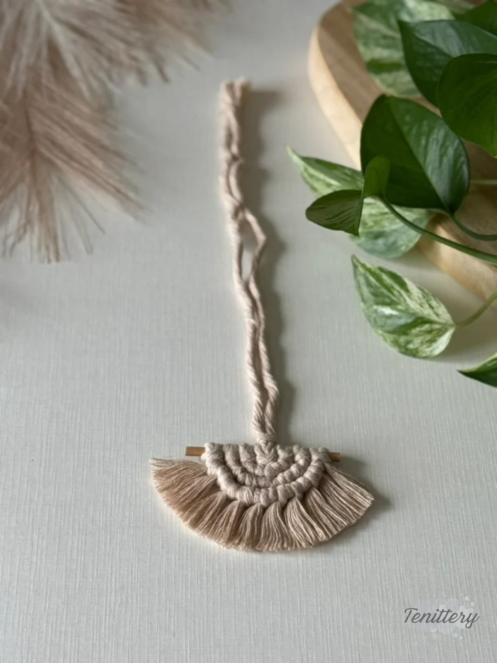 Macramé aromadifuzér Boho v krémové barvě v ruce.