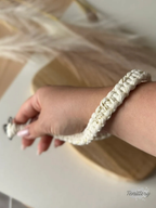 Macramé klíčenka Classic v krémové barvě se zlatou nitkou se silnější karabinou - na ruce.