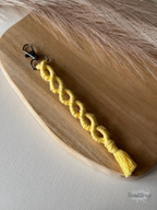 Macramé klíčenka Infinity Long ve světle žluté barvě.