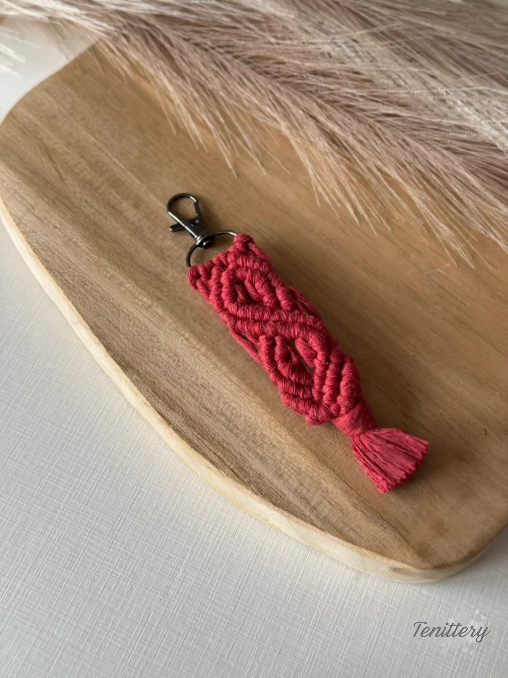Macramé klíčenka Meda v tmavě červené barvě.