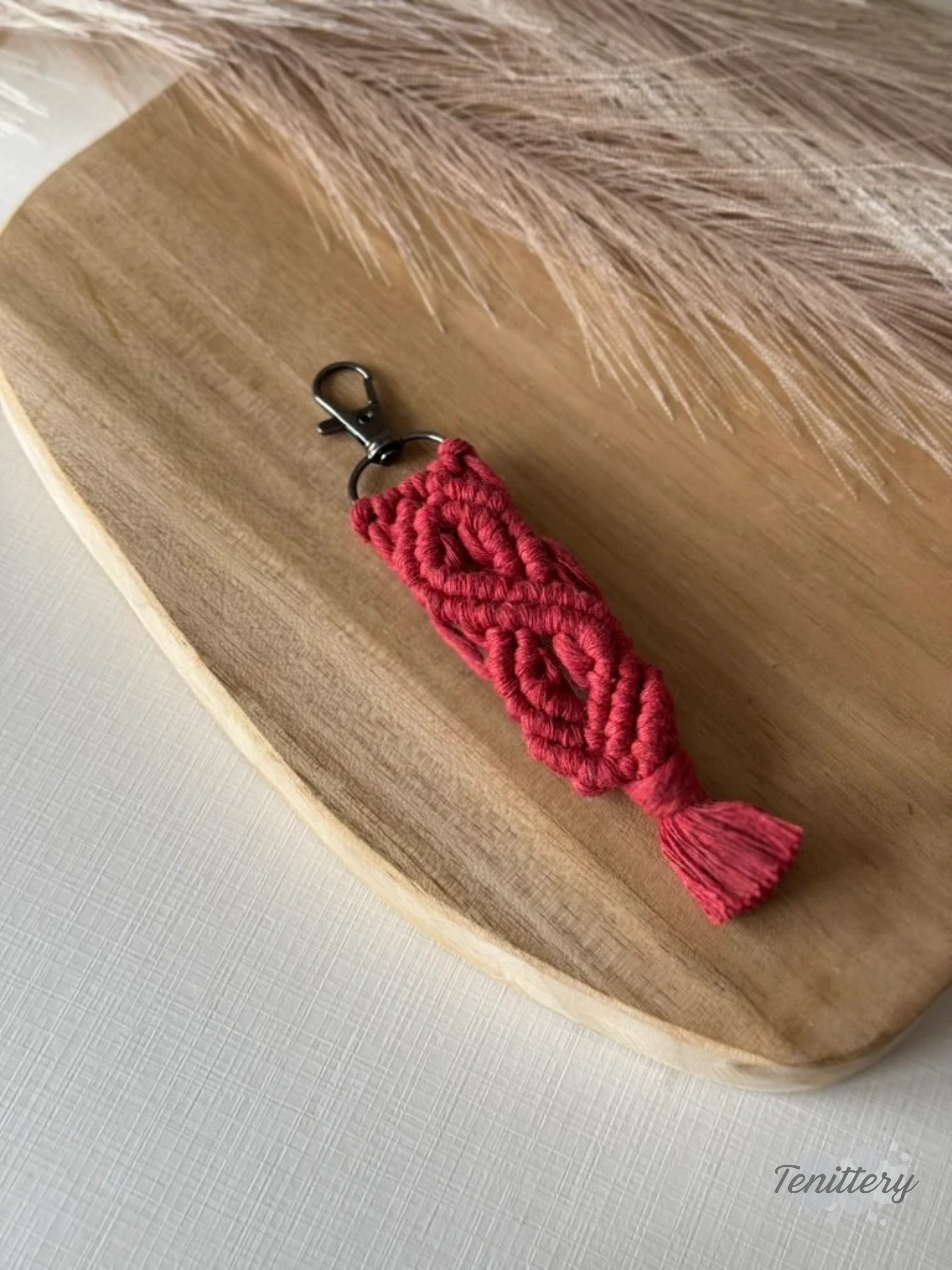 Macramé klíčenka Meda v tmavě červené barvě.