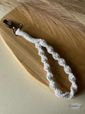 Macramé klíčenka Twist v bílé barvě se stříbrnou nitkou se silnější karabinou.