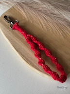 Macramé klíčenka Twist v červené barvě se zlatou nitkou se silnější karabinou.