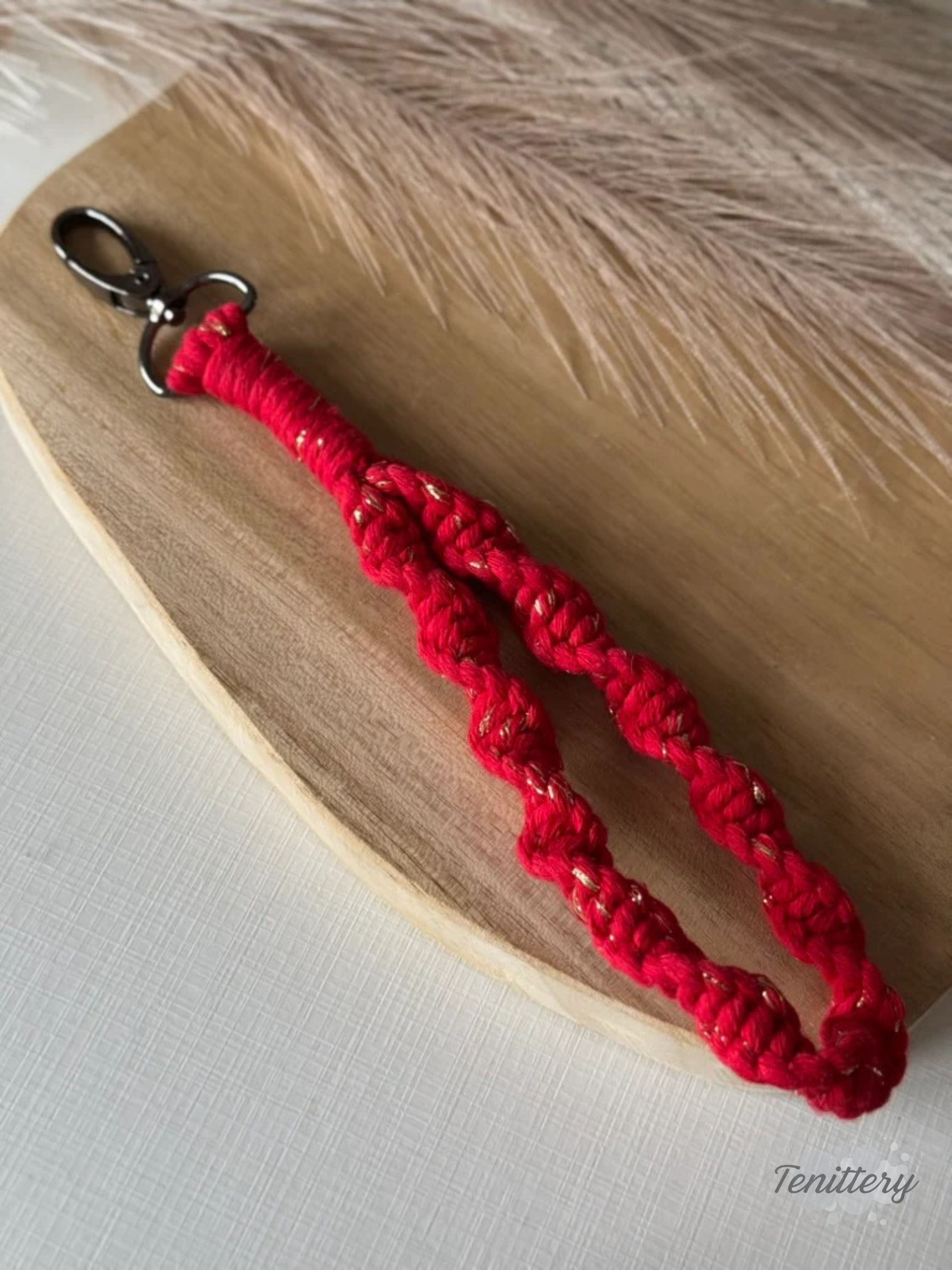 Macramé klíčenka Twist v červené barvě se zlatou nitkou se silnější karabinou.