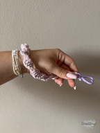Macramé klíčenka Twist v žíhané růžové barvě s růžovou třpytivou nitkou s karabinou ve tvaru srdce v barvě lila - na ruce.