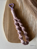 Macramé klíčenka Twist v žíhané růžové barvě s růžovou třpytivou nitkou s karabinou ve tvaru srdce v barvě lila.