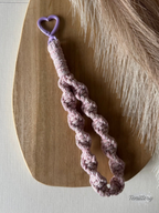 Macramé klíčenka Twist v žíhané růžové barvě s růžovou třpytivou nitkou s karabinou ve tvaru srdce v barvě lila.