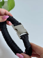Macramé obojek Willow v černé barvě v ruce.